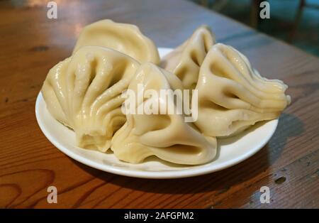 Piastra di Khinkali o zuppa georgiana gnocchi di patate servita su un tavolo di legno Foto Stock
