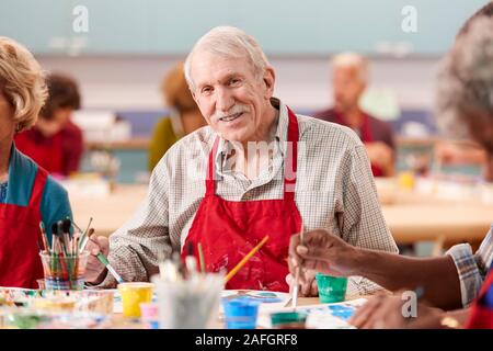 Ritratto di pensionati uomo Senior di frequentare la classe d'arte nel centro comunitario Foto Stock