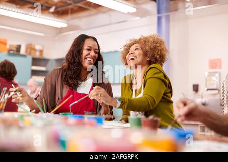 Due donne mature di frequentare la classe d'arte nel centro comunitario insieme Foto Stock