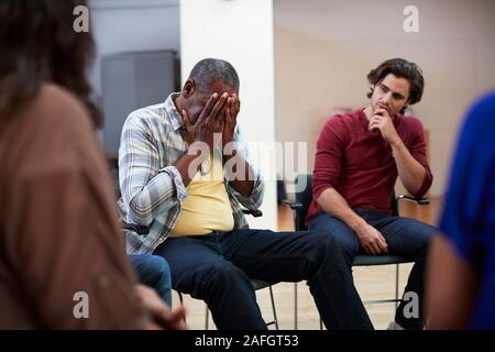 Uomo infelice che frequentano Self Help terapia riunione del Gruppo in centro nella Comunità Foto Stock