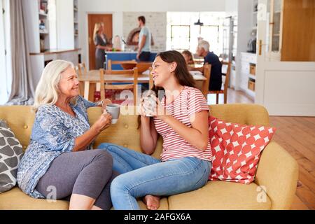 Nonna con nipote adolescente rilassante sul divano e parlando a casa Foto Stock