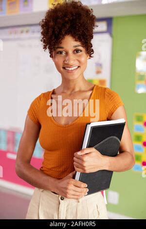 Ritratto di donna insegnante di scuola elementare in piedi in aula Foto Stock