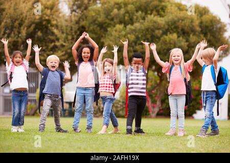 Eccitato Scuola Elementare alunni sul campo da gioco in pausa Foto Stock