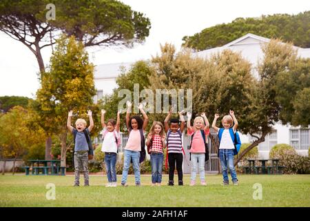 Eccitato Scuola Elementare alunni sul campo da gioco in pausa Foto Stock