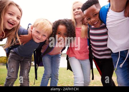 Ritratto di eccitato Scuola Elementare alunni sul campo da gioco in pausa Foto Stock