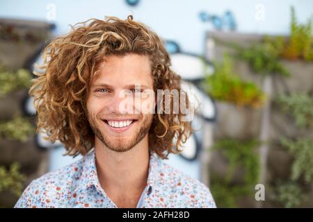 Outdoor testa e spalle Ritratto di sorridente Giovane Uomo Foto Stock