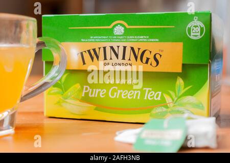 Carrara, Italia - 16 dicembre 2019 - Una scatola di Twinings tè verde su un tavolo con una tazza di tè e un sacchetto da tè Foto Stock