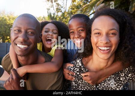 Outdoor Ritratto di famiglia nel giardino di casa contro la svasatura di Sun Foto Stock