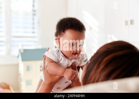 Orgogliosa Nonna Cuddling Baby nipote in vivaio a casa Foto Stock
