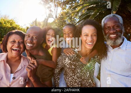 Outdoor ritratto della famiglia Multi-Generation nel giardino di casa contro la svasatura di Sun Foto Stock