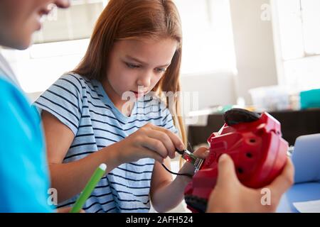 Due studenti In dopo la scuola di computer di classe di codifica imparare a programmare un veicolo robot Foto Stock