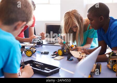 Gli studenti Nel dopo scuola di computer di codifica edificio di classe e imparare a programmare un veicolo robot Foto Stock