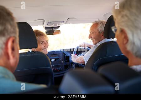 Gruppo di alti amici seduti in auto per vacanza Foto Stock