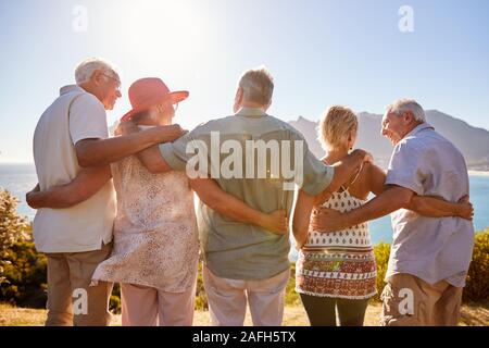 Vista posteriore del Senior amici in visita turistica a Landmark vacanza di gruppo permanente sulla parete Foto Stock