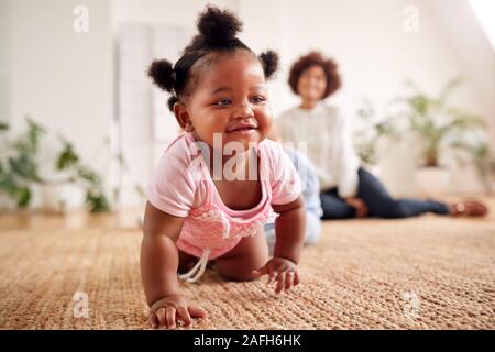 Due madri incontro per data di gioco con i bambini a casa In Appartamento Loft Foto Stock