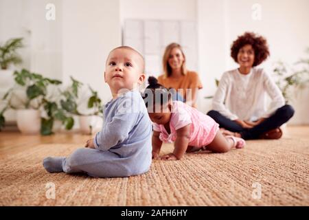 Due madri incontro per data di gioco con i bambini a casa In Appartamento Loft Foto Stock