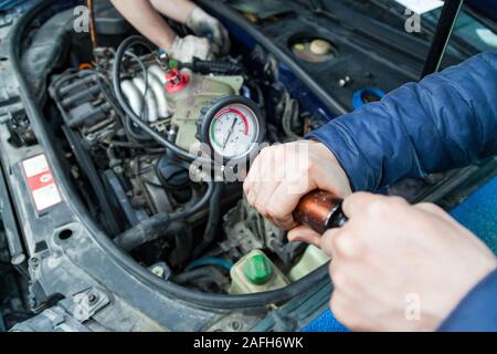 Accumulo di pressione in un serbatoio con antigelo per forzare i tappi di aria nel sistema di raffreddamento del motore di sostituzione del fluido usando una pompa con una scala di pressione Foto Stock