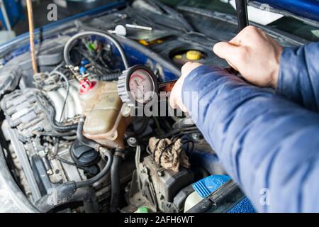 Accumulo di pressione in un serbatoio con antigelo per forzare i tappi di aria nel sistema di raffreddamento del motore di sostituzione del fluido usando una pompa con una scala di pressione Foto Stock