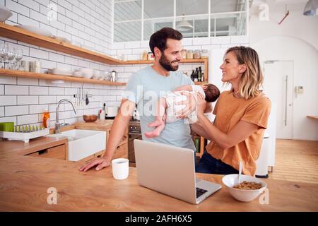 Famiglia di occupato in cucina per la prima colazione con il padre la cura per il bambino figlio Foto Stock