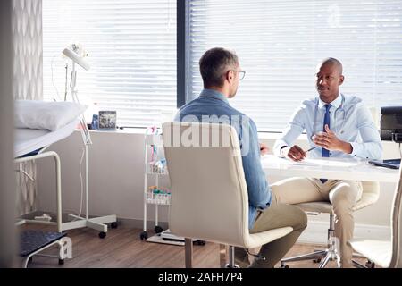 Maschio maturo paziente in consultazione con il medico in ufficio Foto Stock