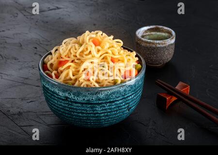 Tagliatelle istante con verdure, con amore e bastoncini, un close-up su sfondo scuro Foto Stock