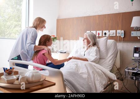 Nipote di parlare con la Nonna sulla famiglia visita all'ospedale Foto Stock
