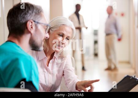 Medico accogliente per Senior paziente femmina essendo ricoverato in ospedale Foto Stock