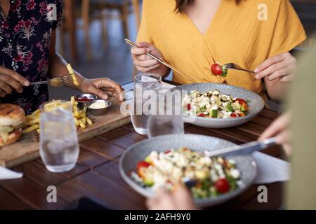 Close Up di amiche a mangiare cibo al tavolo nel ristorante Foto Stock