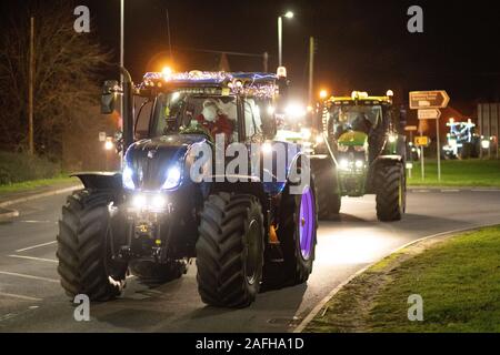 Gli agricoltori da Leicestershire e Warwickshire hanno tenuto il loro primo trattore tour di Natale. A partire dal Sheepy Magna hanno girato villaggi locali. Foto Stock