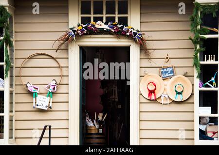 Ghirlanda di Natale oltre la porta aperta del William Pitt store, Colonial Williamsburg. Visibile merci comprendono Hotch Potch bambole, cappelli di paglia e bacchette. Foto Stock