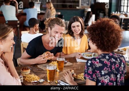 Un gruppo di giovani amici incontro per un drink e il cibo nel ristorante Foto Stock