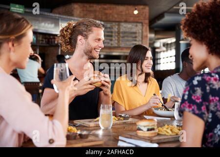 Un gruppo di giovani amici incontro per un drink e il cibo nel ristorante Foto Stock