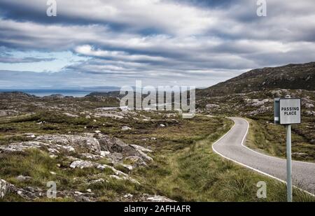 Passando il cartello del posto sulla remota strada a binario singolo tra i paesaggi ariosi sull'Isola di Lewis e Harris, Le Ebridi Esterne, Scozia Foto Stock