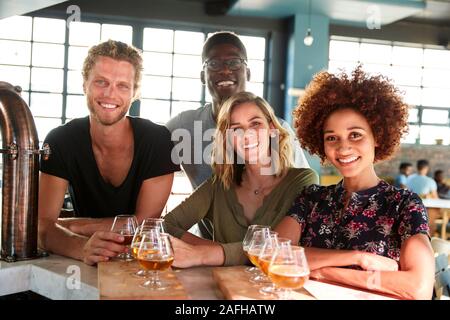 Ritratto di gruppo di amici Degustazione di birra seduti al bar Foto Stock