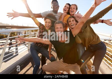 Ritratto di giovani amici all'aperto in posa sulla passerella insieme Foto Stock