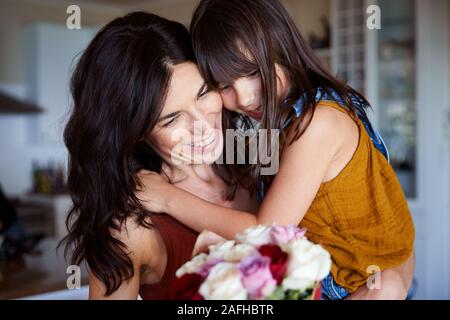 Giovane ragazza bianco dando la sua madre fiori come un regalo per la Festa della mamma, close up Foto Stock