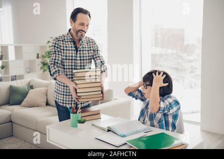 Stanco esaurito sorpreso schoolkid desidera camminare con i suoi amici e hanno il weekend ma il suo papà lo rendono il soggiorno a casa e continuare a studiare dando Foto Stock