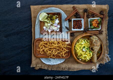 Stile settentrionale salsa speziata zuppa di noodle con latte di cocco (Khao soi), tradizionale del nord della cucina Thailandese, vista dall'alto. Foto Stock