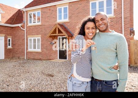 Ritratto di giovane tenendo premuto i tasti in piedi al di fuori di nuovo Home Il giorno del trasloco Foto Stock