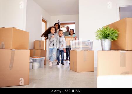 Famiglia sorridente Scatole di trasporto nella nuova casa il giorno del trasloco Foto Stock