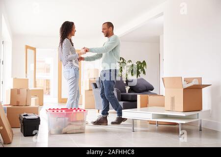 Amare giovane circondato da caselle nella nuova casa il giorno del trasloco Foto Stock