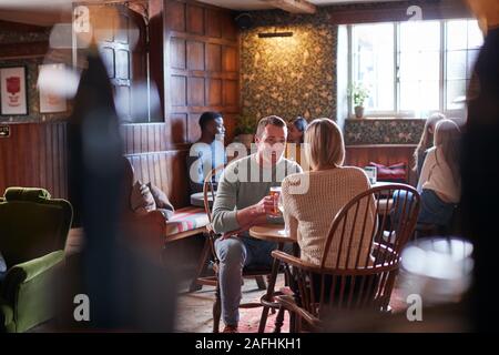 Due sale riunioni per pranzo bevande nel tradizionale Pub Inglese facendo un brindisi Foto Stock