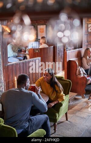 Due sale riunioni per pranzo bevande nel tradizionale Pub Inglese facendo un brindisi Foto Stock