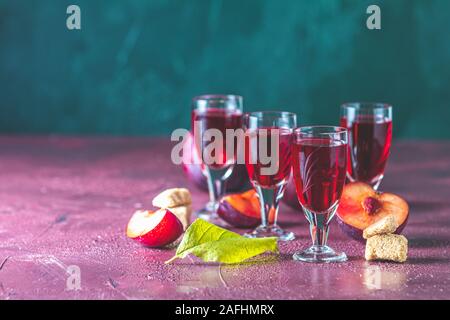 Le prugne forte bevanda alcolica in scatti vintage. Liquori, slivovica, brandy alla prugna prugna o vodka con susine mature Foto Stock