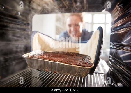 Vista guardando fuori dall'interno del forno come donna brucia la cena Foto Stock