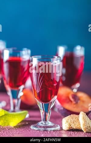 Le prugne forte bevanda alcolica in scatti vintage. Liquori, slivovica, brandy alla prugna prugna o vodka con susine mature Foto Stock