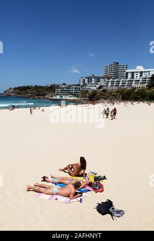 Sydney prendere il sole - bagnanti in vacanza sulla spiaggia di Bondi in una giornata soleggiata in estate, Sydney, Australia Foto Stock