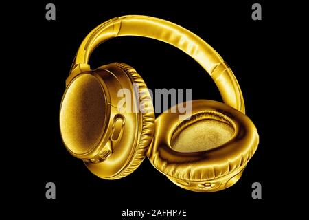 Golden shiny cuffie wireless su sfondo nero isolato vicino, Luxury Gold metal auricolare bluetooth, moderno ed alto fine wi-fi auricolari giallo Foto Stock