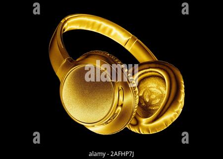 Golden shiny cuffie wireless su sfondo nero isolato vicino, Luxury Gold metal auricolare bluetooth, moderno ed alto fine wi-fi auricolari giallo Foto Stock