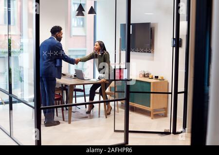 Imprenditrice stringono le mani con maschio Candidato al lavoro in sala riunioni dopo il colloquio Foto Stock